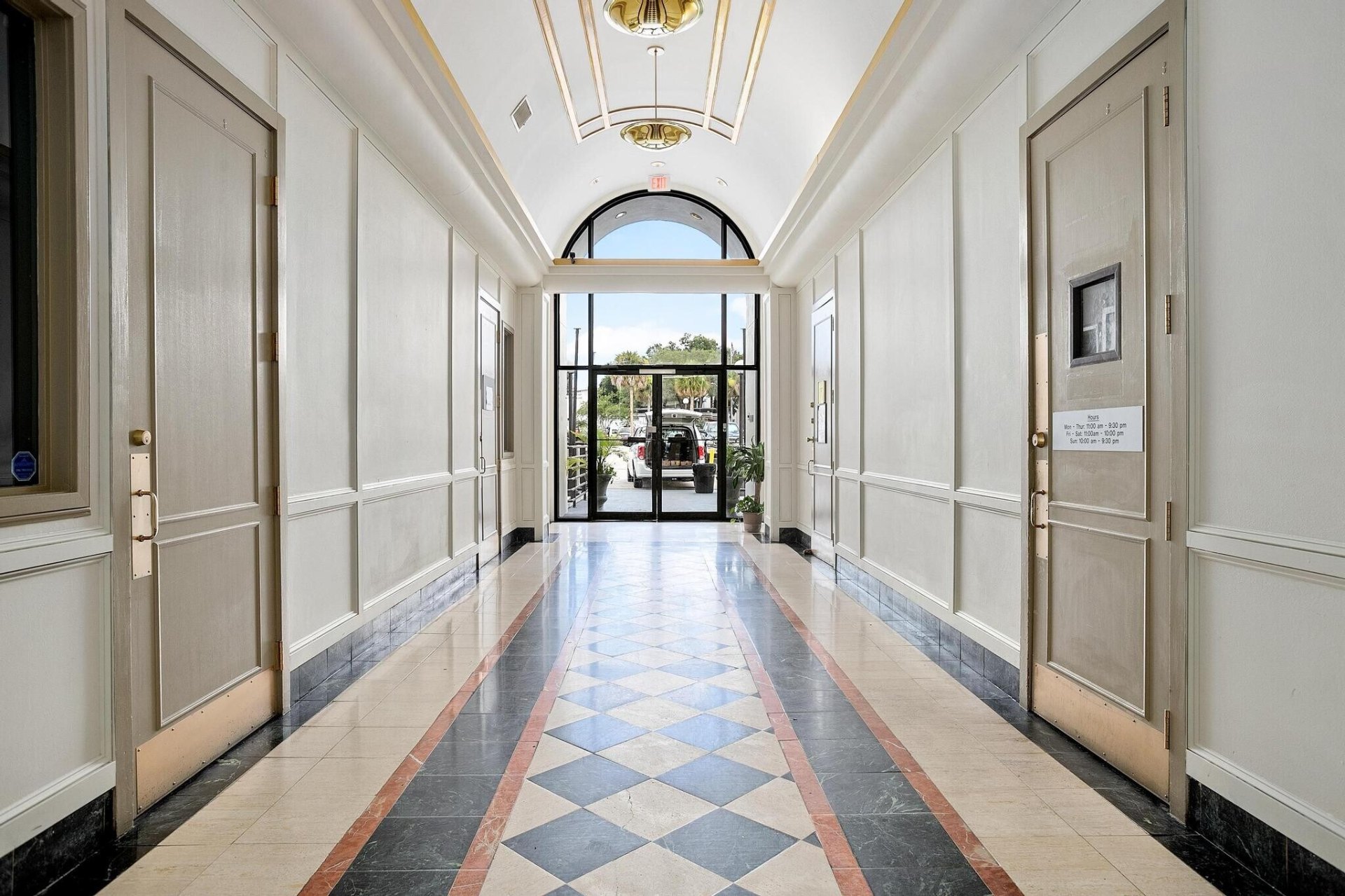Elegant interior corridor at New York Plaza with vaulted ceiling, paneled walls, and a marble checkerboard floor