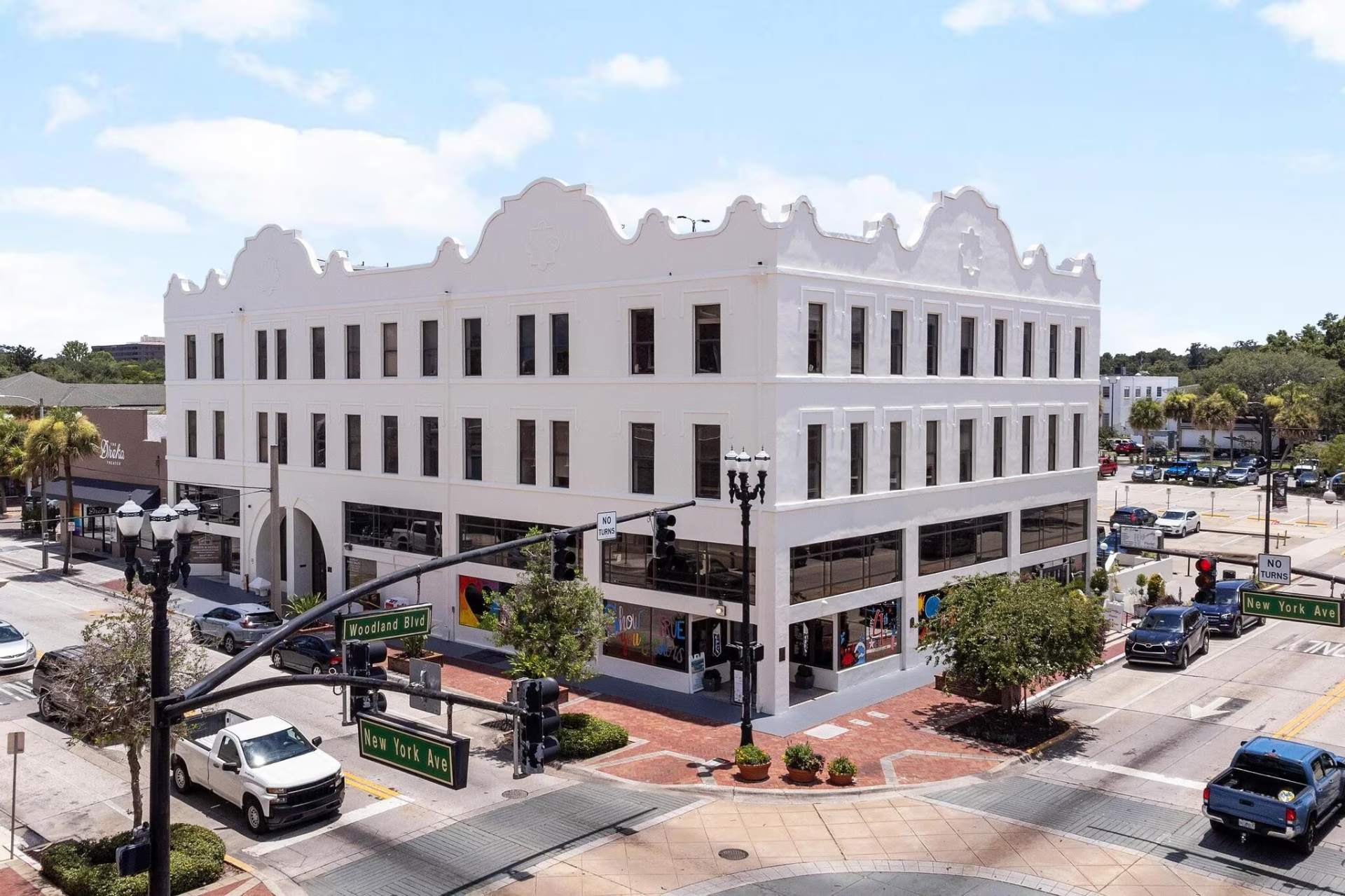 Aerial view of New York Plaza's white Mediterranean Revival facade in downtown DeLand