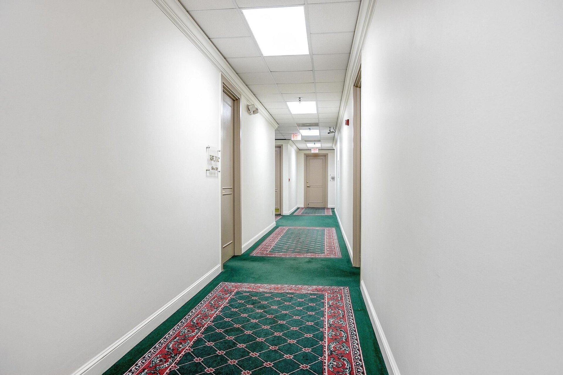 Interior tenant corridor with traditional carpet runner and paneled doors