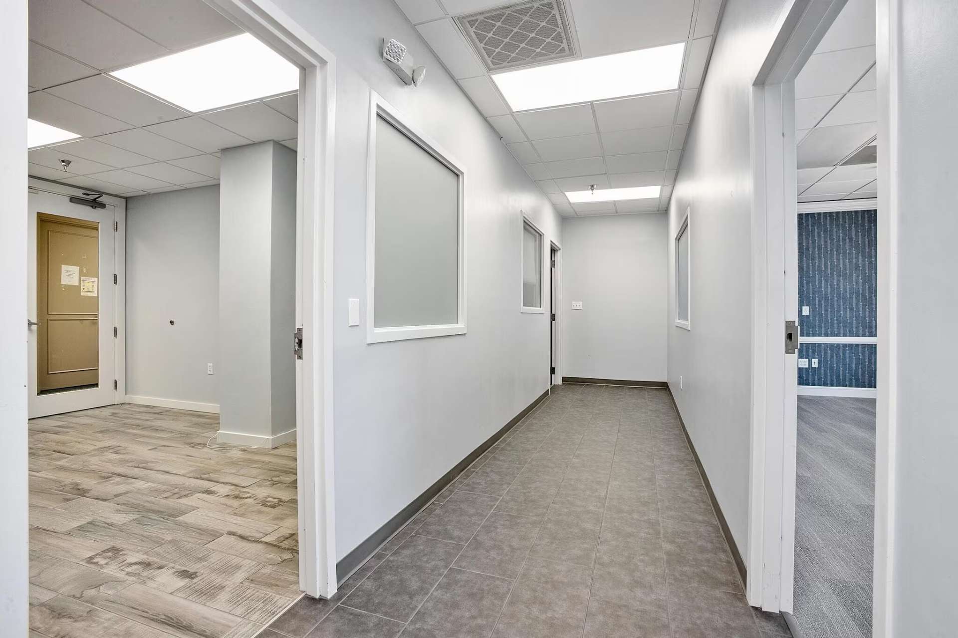 Bright interior tenant corridor with frosted office windows and tile flooring